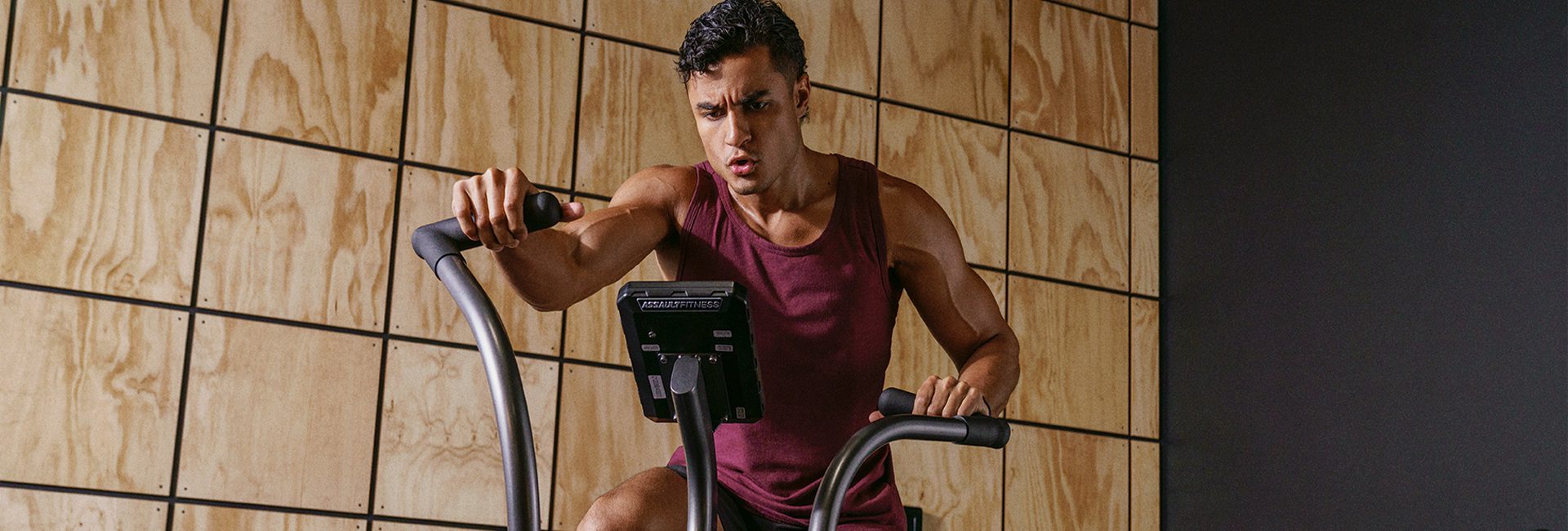 man riding a VIZMOX spin bike in a modern gym