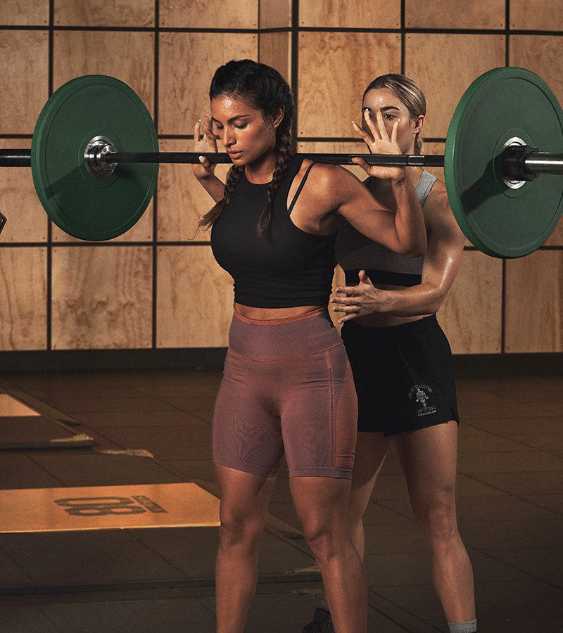 woman lifting weights with a personal trainer